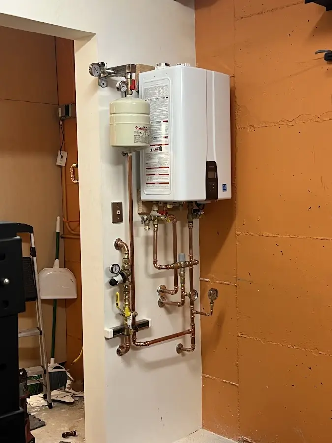 Plumbing technician inspecting water heater connections in Lincoln Park